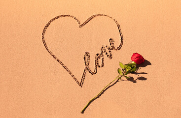 Writing on sand beach love, heart and red rose. Romantic symbol, Valentin's day concept. 
