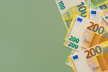Money background.One and two hundred euro banknotes on a green background.Money and finance.Finance...