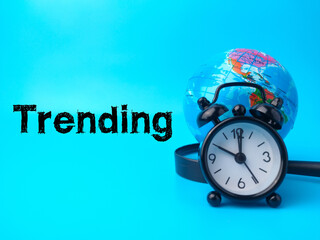 Magnifying glass,earth globe and clock with text Trending on blue background.