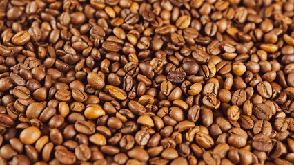 Texture of freshly coffee beans. Lots of roasted beans for preparation of fragrant drink. Close up.