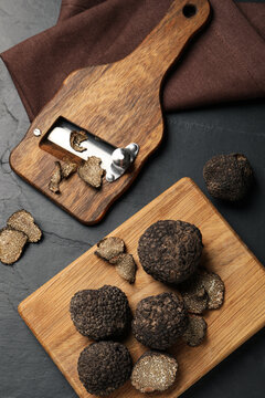 Wooden Shaver With Whole And Sliced Truffles On Black Table, Flat Lay