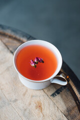 red tea with rosebuds on wood barrel