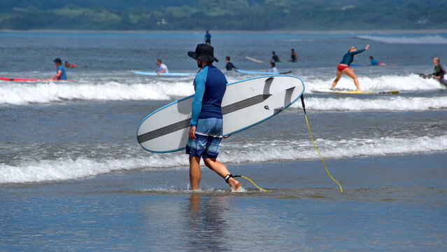 Man Carrying A Surf Board In Tamarindo, Costa Rica