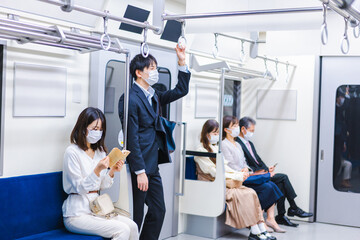 マスクをして電車に乗る人々