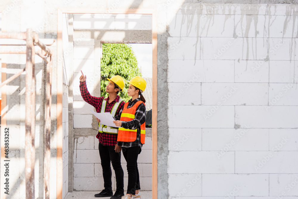 Poster architect and client discussing the plan with blueprint of the building at construction site. asian 