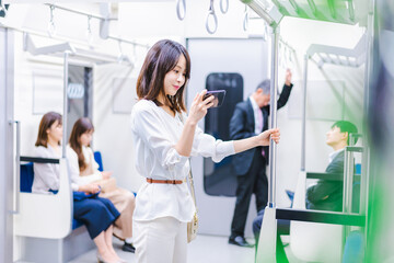 電車で動画配信サービスを利用する女性