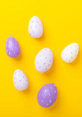 Multicolored easter eggs on yellow background. Easter concept. Top view. Copy space