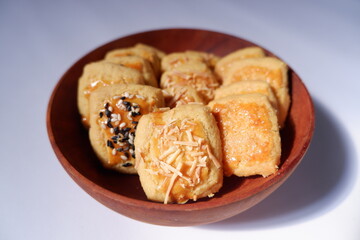 homemade butter cookies in a wooden bowl, on a gray background. snacks, biscuits, made of flour, eggs, sugar topped with sugar, sesame or cheese. eaten at tea time