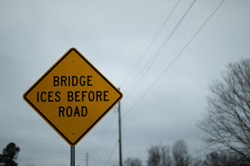 A yellow bridge ices before the road sign 