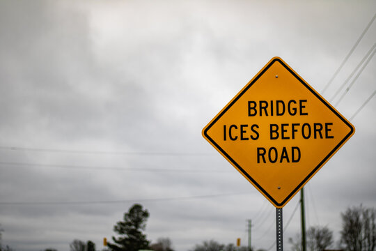 A yellow bridge ices before the road sign 