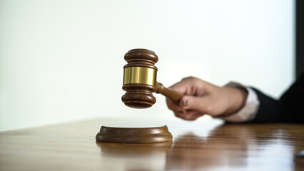 Close up hand of female lawyer holding gavel.