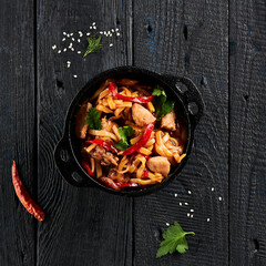 Japanese stir fryed udon noodles in wok. Udon noodle with chiken and vegetables on wooden...