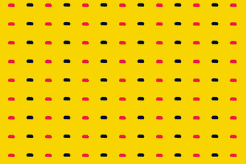 Colorful pattern of pink and black kitchen sponges on yellow background. Top view. Flat lay. Pop art design