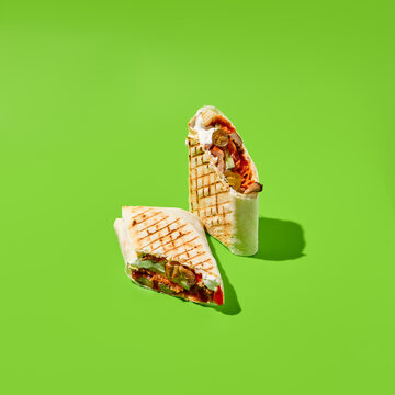 Shawarma with vegetables and meat on green background. Contemporary poster with shawarma. Doner kebab in minimal style. Street food concept. Junk food design. Minimalistic fast food menu.