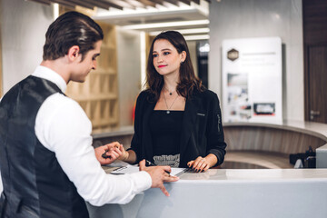 Young handsome businessman talking and check in Register information with woman receptionist worker...