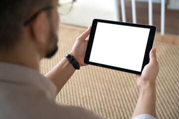 Closeup of Indian man holding digital tablet sitting on sofa at home office