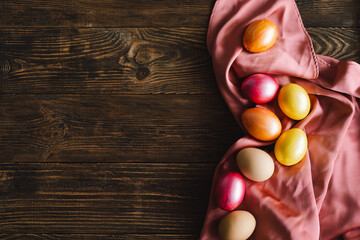 Multicolored Easter eggs on a wooden background. Easter background. Copy space. Easter eggs flat lay on rustic table. Easter concepts
