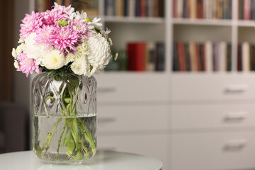 Bouquet of beautiful chrysanthemum flowers on white table indoors, space for text