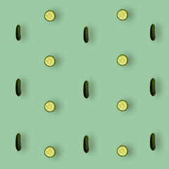 Colorful pattern of fresh cucumbers on green background with shadows. Top view. Flat lay. Pop art design