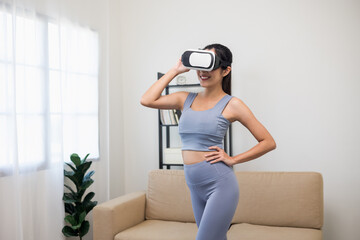 Fototapeta na wymiar Young asian sport woman put on vr glasses wearing sportswear workout with virtual simulated world. Into the future digital cyber universe. Future technology Training virtual sport at home