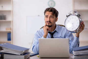 Young male employee in time management concept