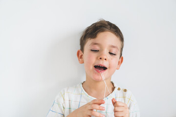 Cute boy pulling loose tooth using a dental floss. The boy's first milk tooth is loose. Toothache....