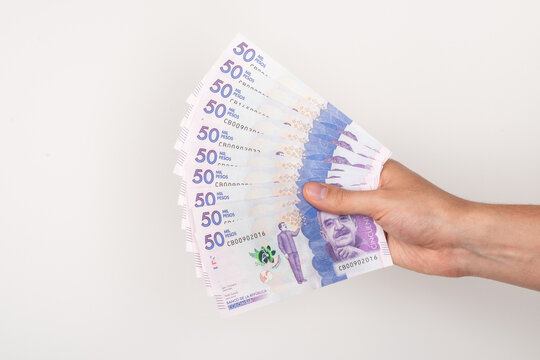 Hand holding colombian money