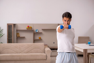Fototapeta na wymiar Young man doing sport exercises at home