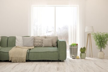 Modern living room in white color with sofa and winter landscape in window. Scandinavian interior design. 3D illustration