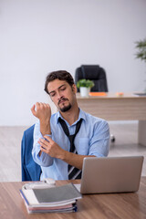 Young male employee unhappy with excessive work in the office