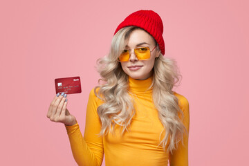 Trendy woman showing plastic card in studio