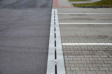 Fototapeta premium drainage element in interlocking paving concrete gutter with slotted drain from one piece of concrete can hold water from the parking lot along the entire length of the yard