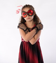 Beautiful mixed race little girl in glamorous red mardis gras mask and black gloves  - 483864646
