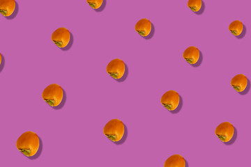 Colorful fruit pattern of fresh persimmons on pink background. Top view. Flat lay. Pop art design