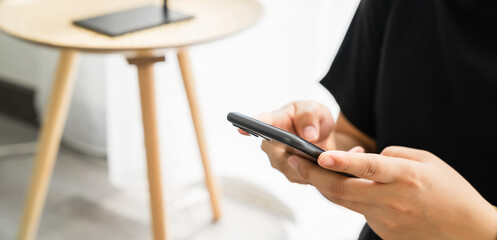 Hand holding smartphone and chatting with friends at social network on the table.