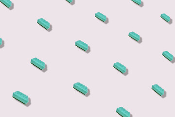 Colorful pattern of turquoise kitchen sponges on grey background. Top view. Flat lay. Pop art design