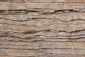Natural stone wall, flagstone. Geological section of sedimentary rocks. Background for wallpaper, texture.