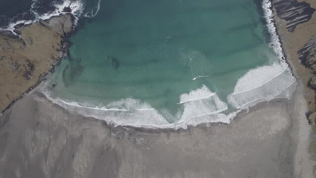 Aerial view above waves at the Bunes beach, in gloomy Lofoten, Norway - top down, drone shot