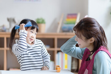 折り紙で遊ぶ園児と保育士