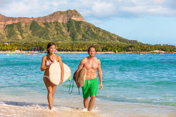 Hawaii surfers couple surf people having fun surfing on Waikiki beach, Honolulu, Oahu island,...