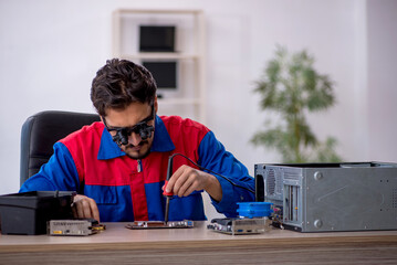 Young male repairman repairing computer