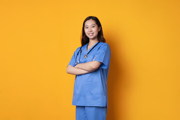 Asian doctor standing with her arms crossed smiling at the camera