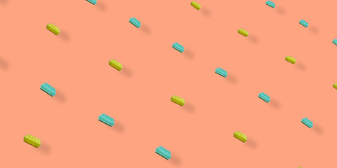 Colorful pattern of yellow and turquoise kitchen sponges on orange background with shadows. Top view. Flat lay. Pop art design