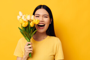 Charming young Asian woman with a bouquet of yellow flowers romance studio model unaltered