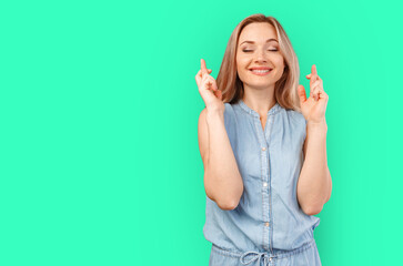 Young woman wishing for good luck isolated on color background