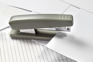 Stapler on a background of paper and letterhead.