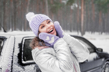Beautiful smiling woman has fun outdoors. Woman in snowy forest. Winter vacation.