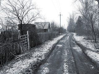 Dirt road in the village in winter.