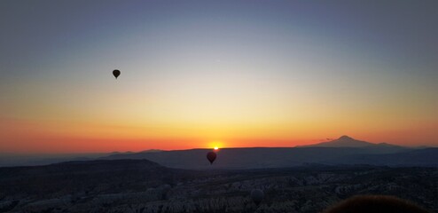 Obraz premium sunrise in the mountains under air ballons