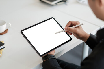 Asian male drawing on a white blank screen computer tablet with pen stylus